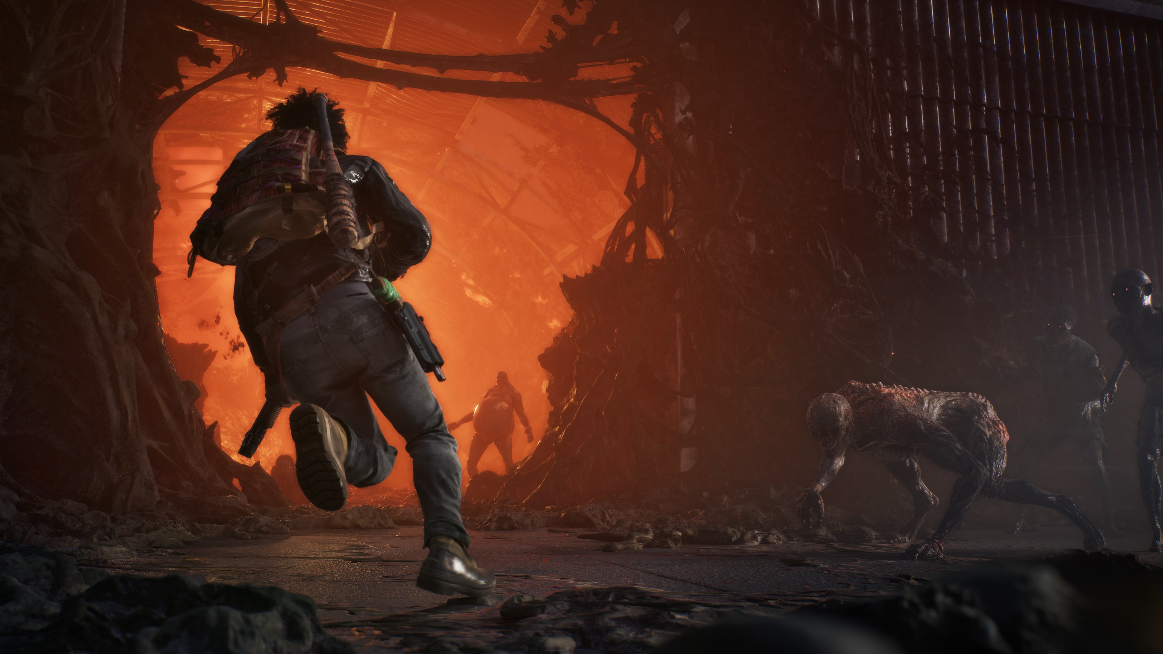 A survivor sprints out of a plague infestation lit orange from within while a feral zombie lopes alongside on all fours