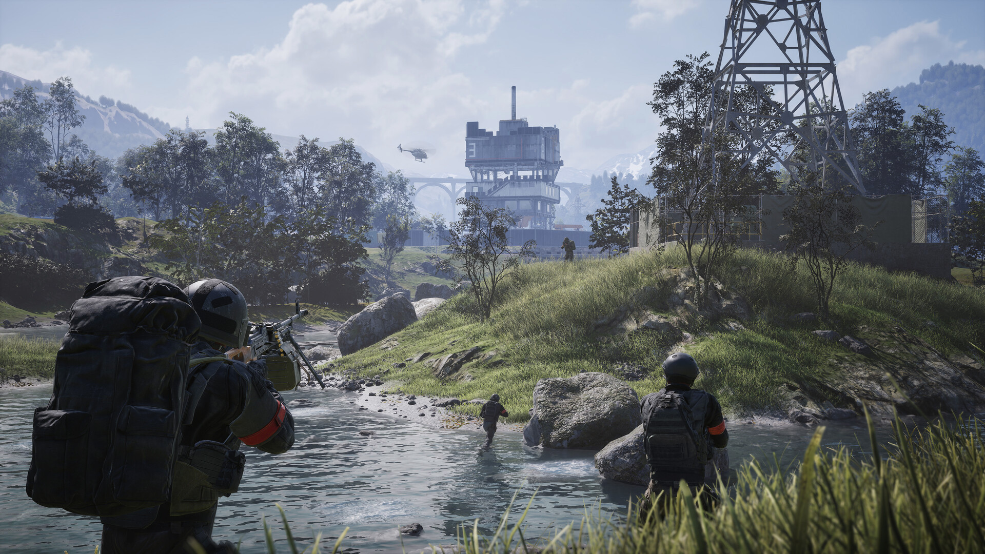 Three WARDOGS soldiers in red faction armbands wade a shallow river toward a derelict industrial tower as a helicopter passes overhead