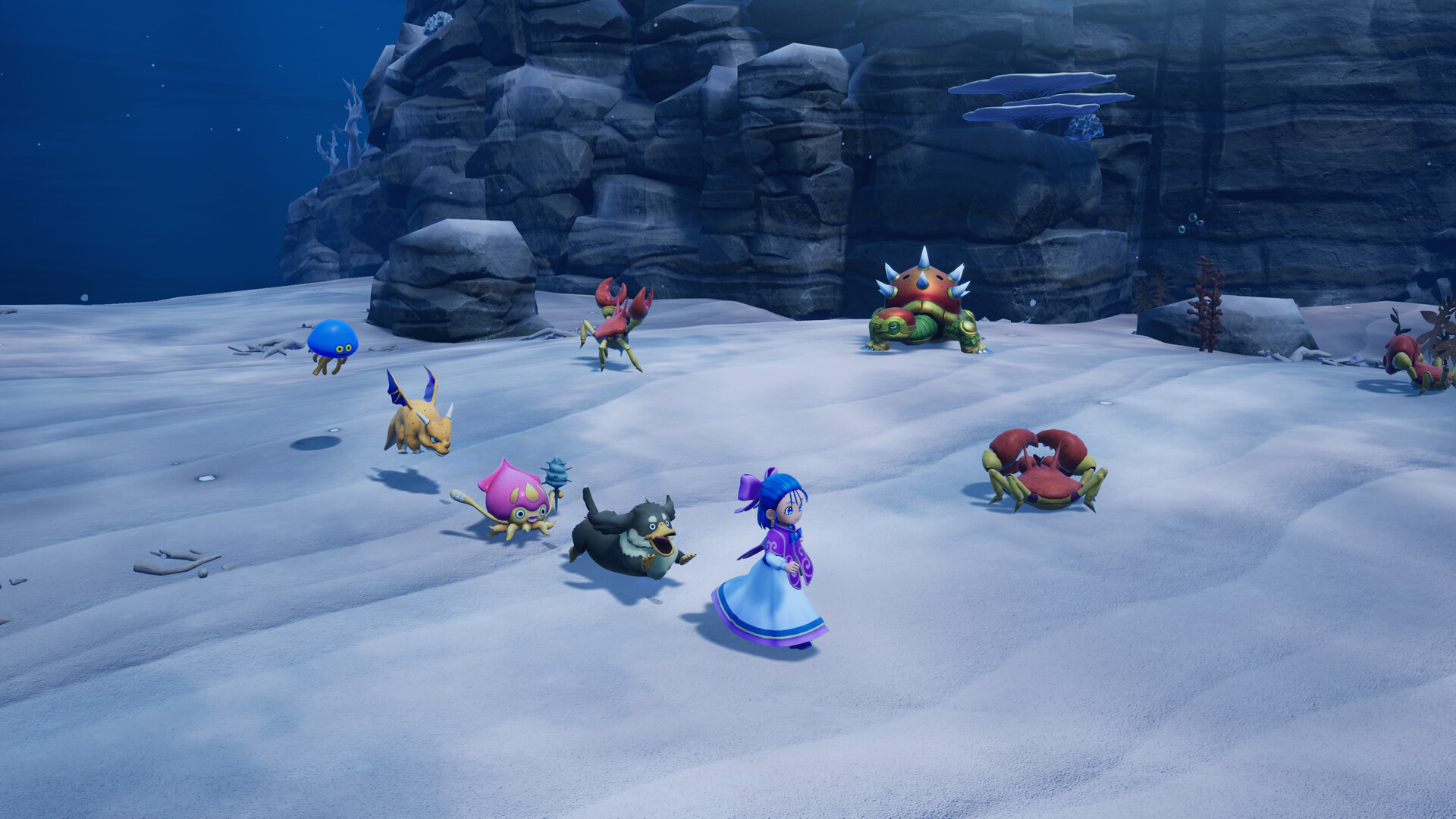 The ocean floor area: a pale seabed with rock outcrops and several aquatic monsters gathered around a monster wrangler