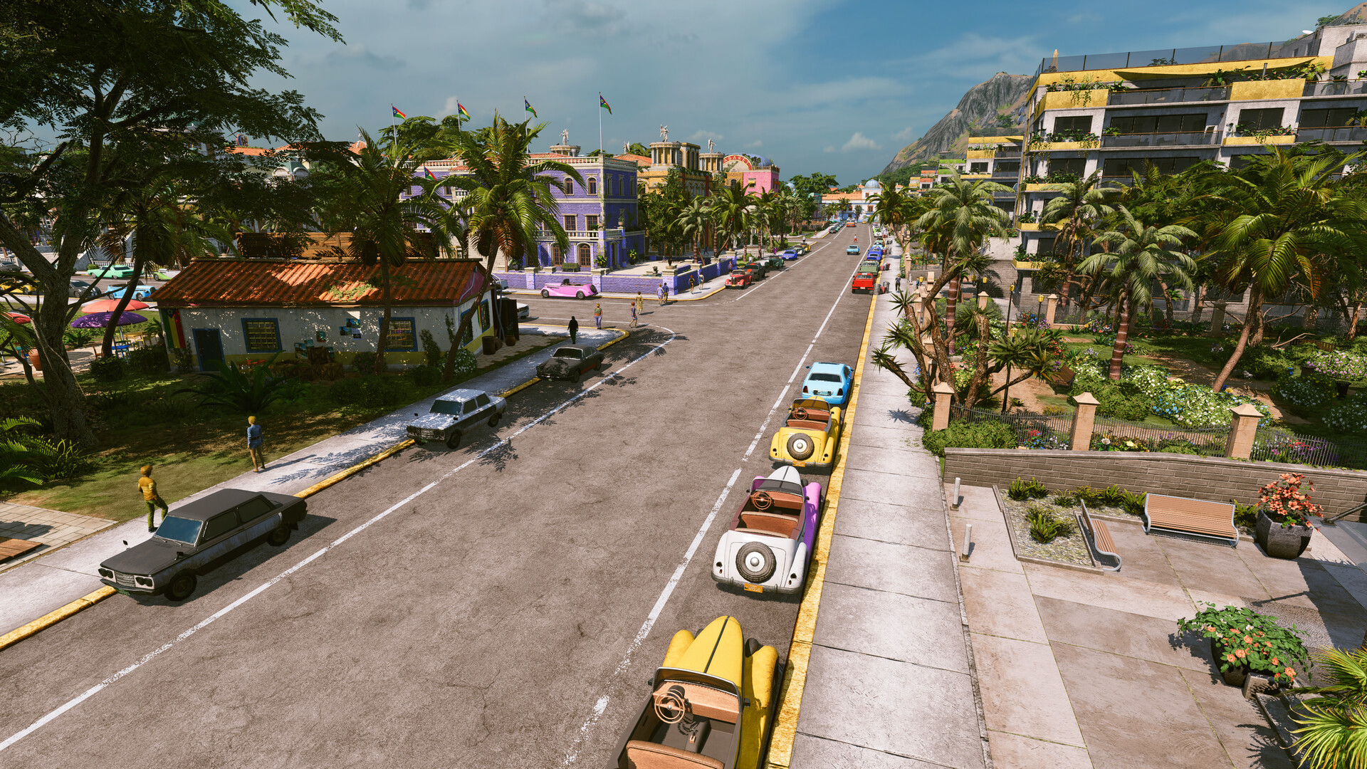 Tropico 7 city street lined with parked vintage cars, palm trees and colorful buildings