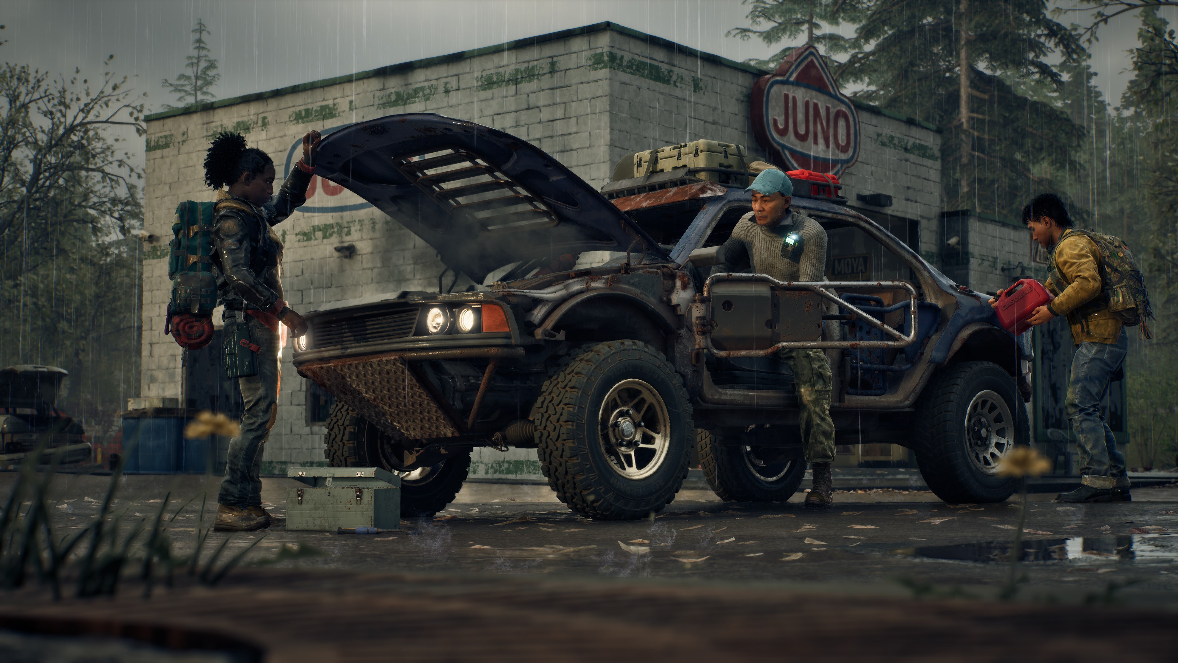 Three survivors work on an off-road vehicle in the rain outside a roadside gas station, one refuelling it from a red jerry can while another checks under the raised hood