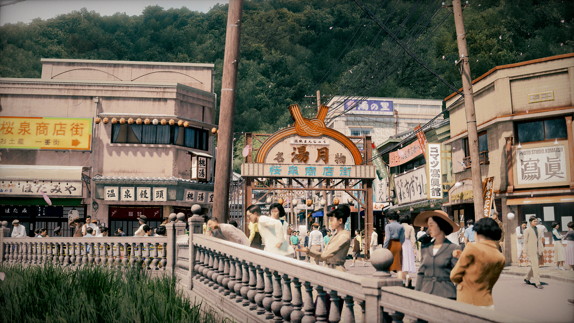 A hot-spring resort shopping arcade busy with tourists beneath a decorated gate, souvenir shops and a photography studio lining the street