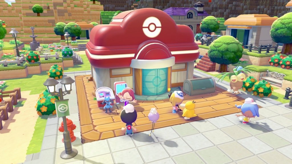 The Pokemon Center building in a lush town surrounded by gardens, street lamps, and visiting Pokemon and players