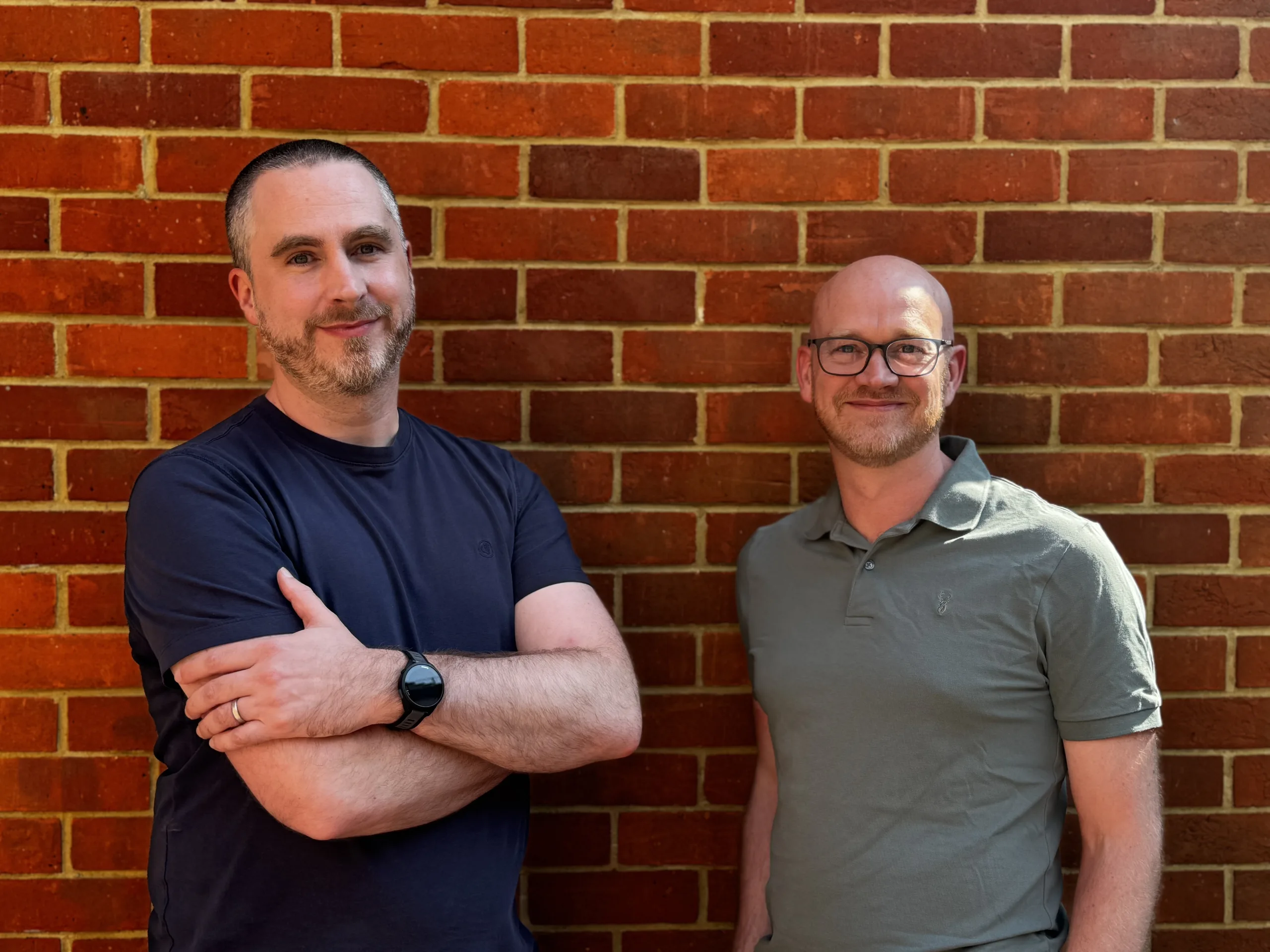 Fuse Games Game Director Bill Lane and Design Director Mark Bridges in front of a red brick wall