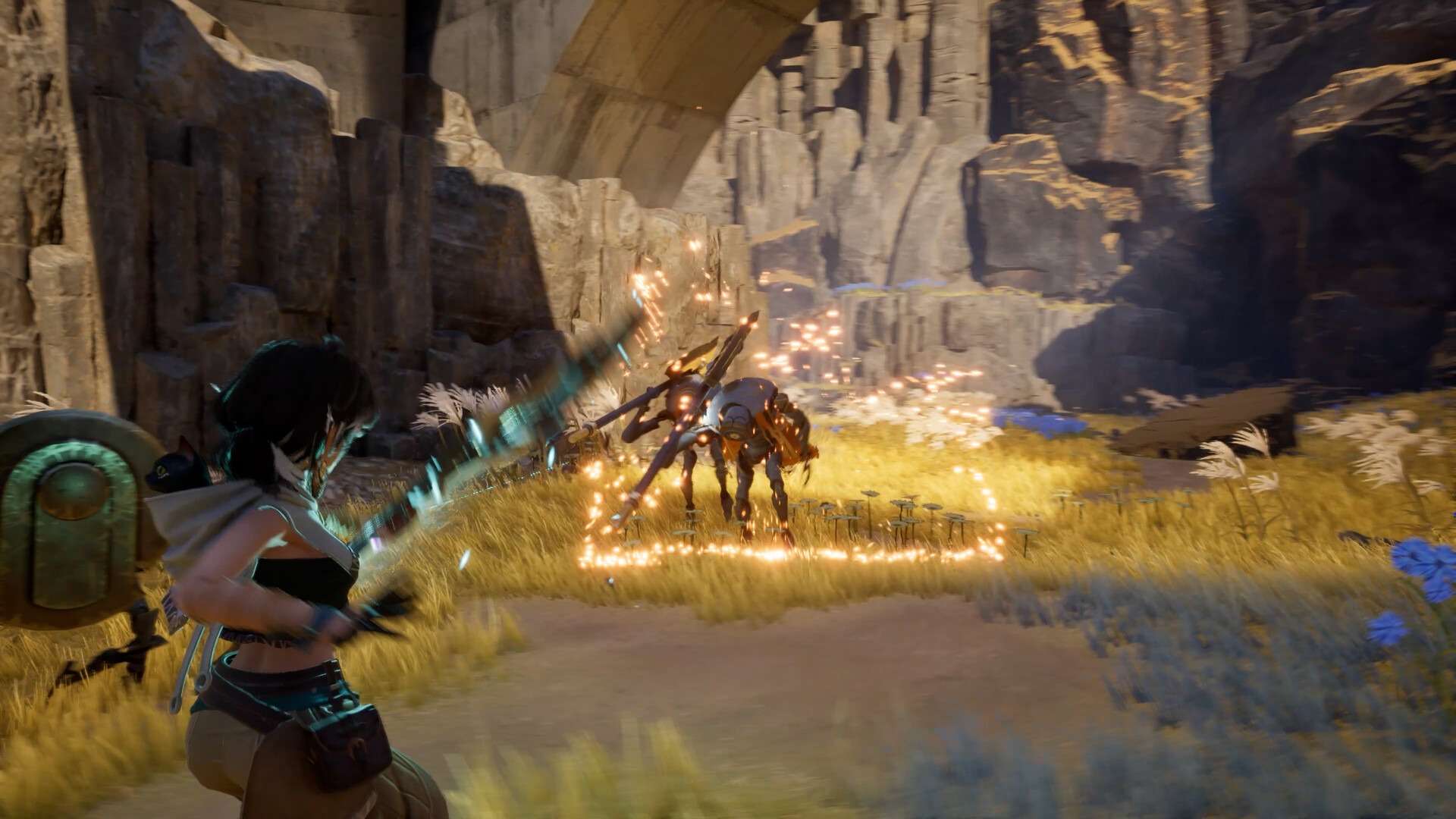Molly swings a weapon in a cyan arc at a four-legged mechanical enemy that scatters orange sparks across golden grass, the small cat riding at her shoulder beside a round green device, under stone arches