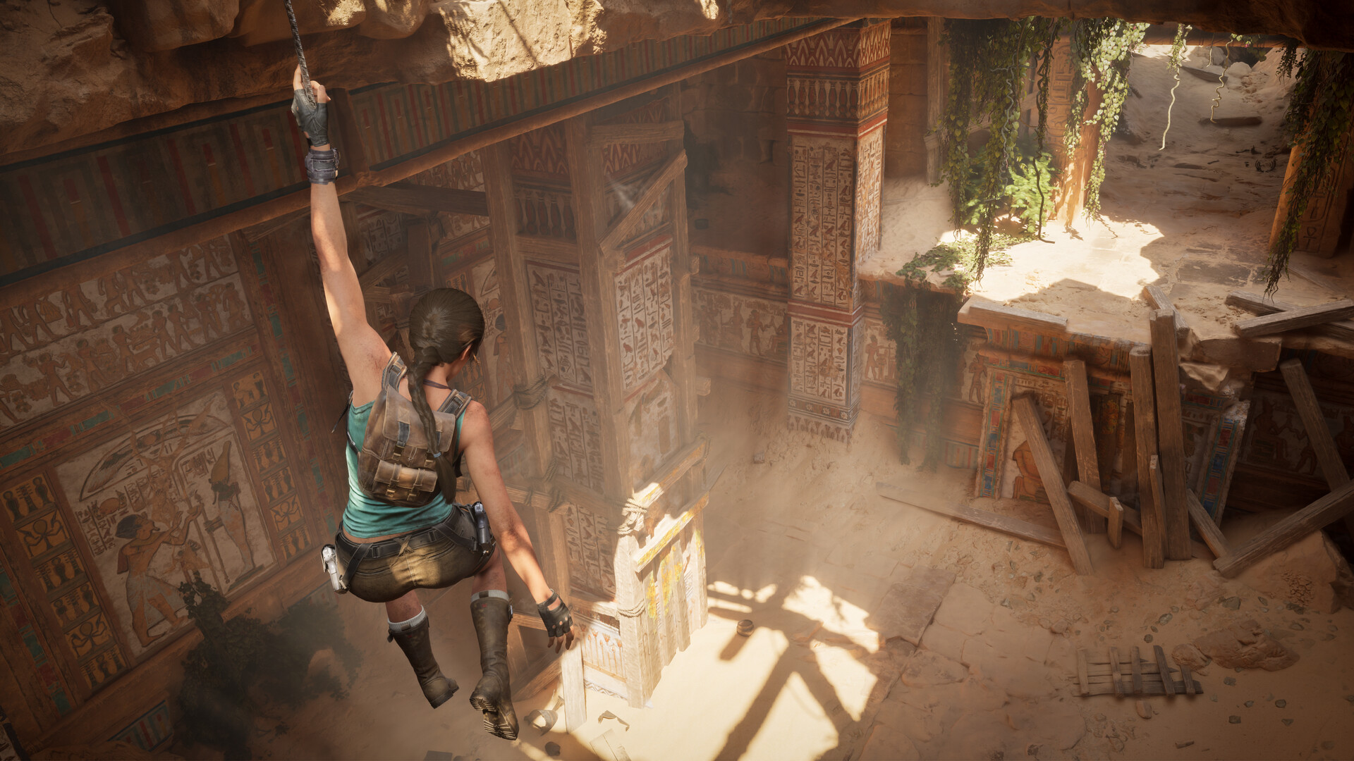 Lara Croft rappels on a rope into a painted hieroglyphic tomb chamber in Egypt