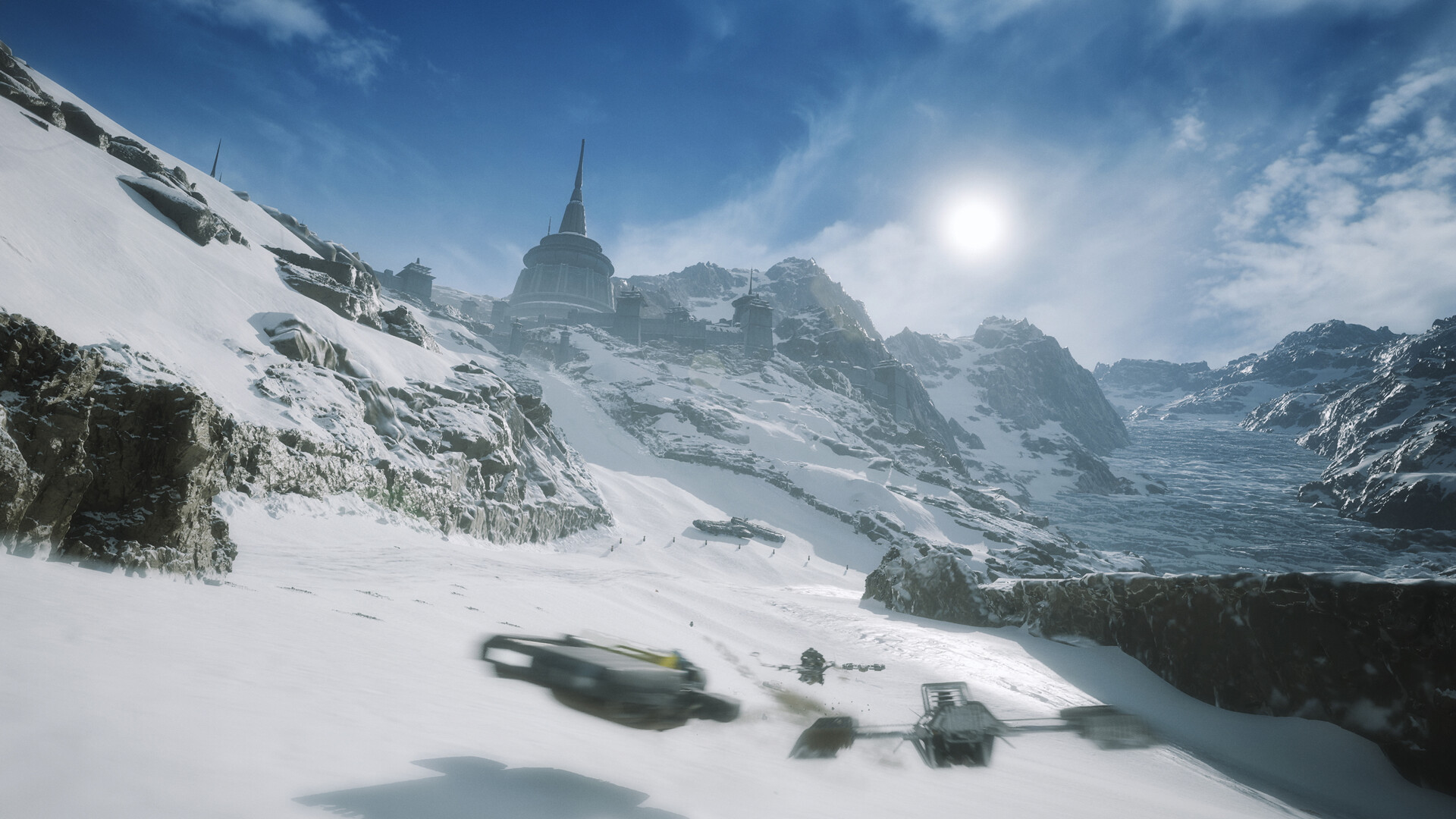 Wide Ando Prime snow valley with a tall spire complex and two racers below