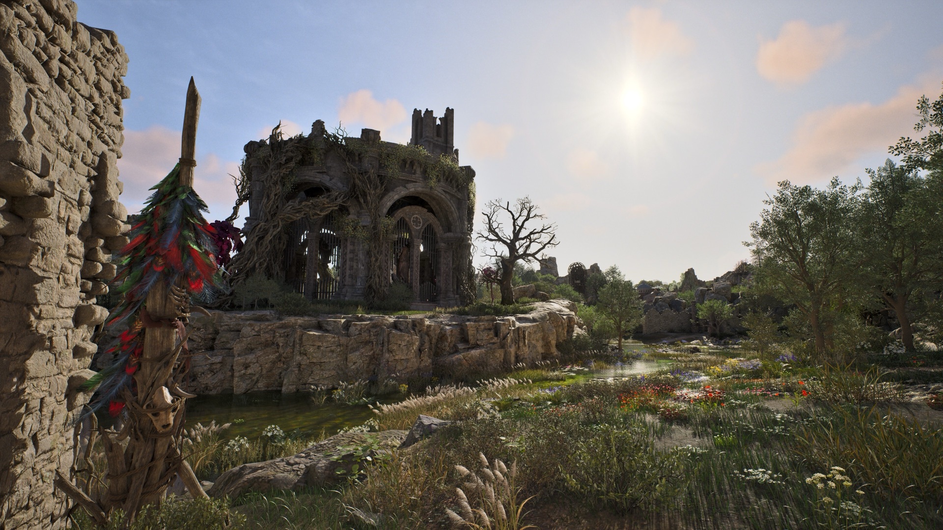 An overgrown stone ruin under a bright sky in ArcheAge Chronicles, with a feathered wooden totem in the foreground and wildflowers along a stream