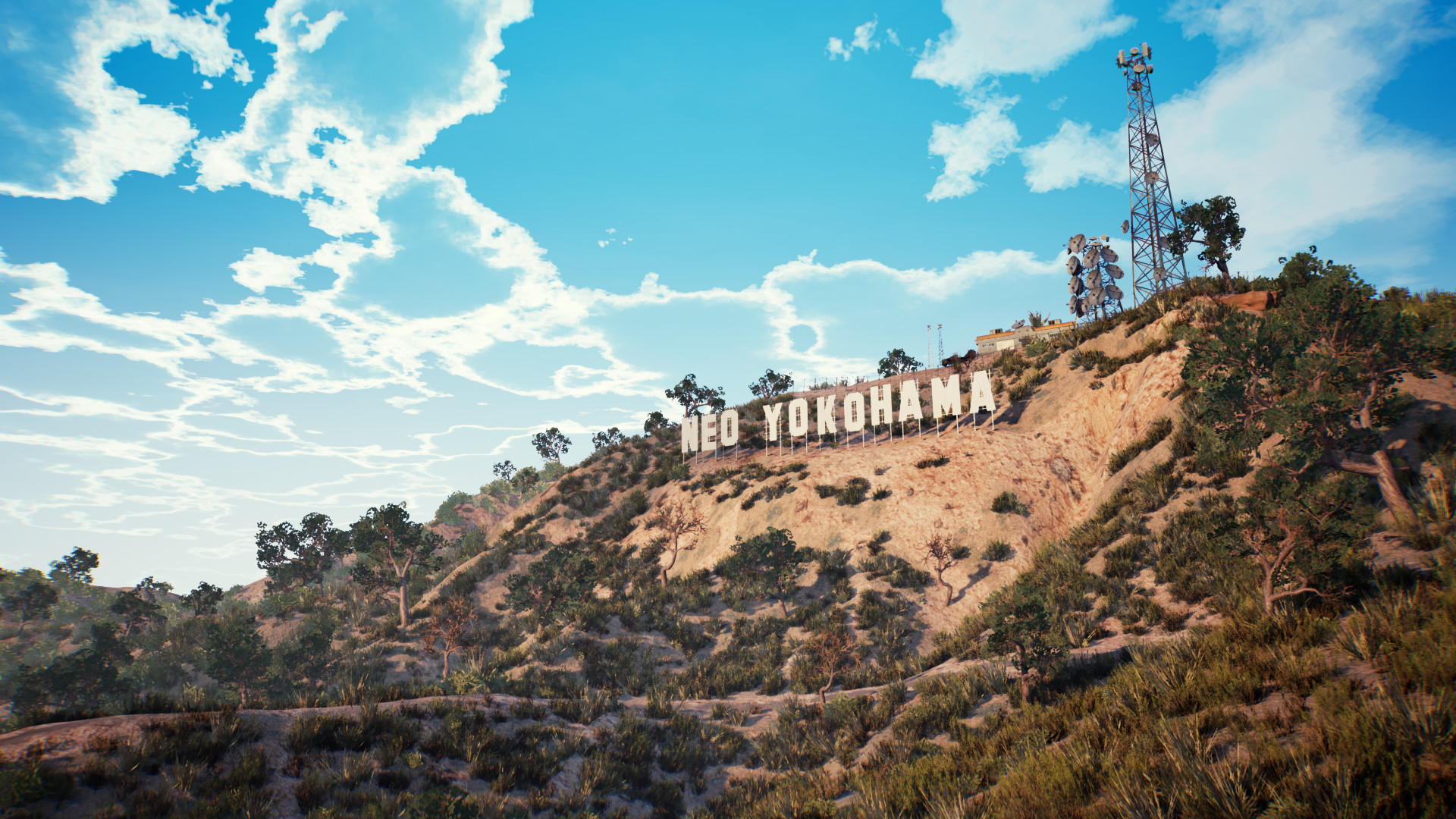 The NEO YOKOHAMA hillside sign standing on a scrubby ridge above the city, with a radio mast and satellite dishes on the summit behind it