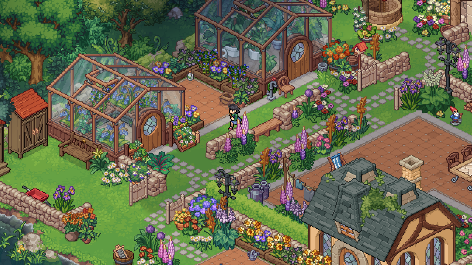 Two glass greenhouses on the cottage grounds, surrounded by stone-edged flower beds, lupins and daisies, with paved paths, a garden bench, a wheelbarrow, a shed and a well