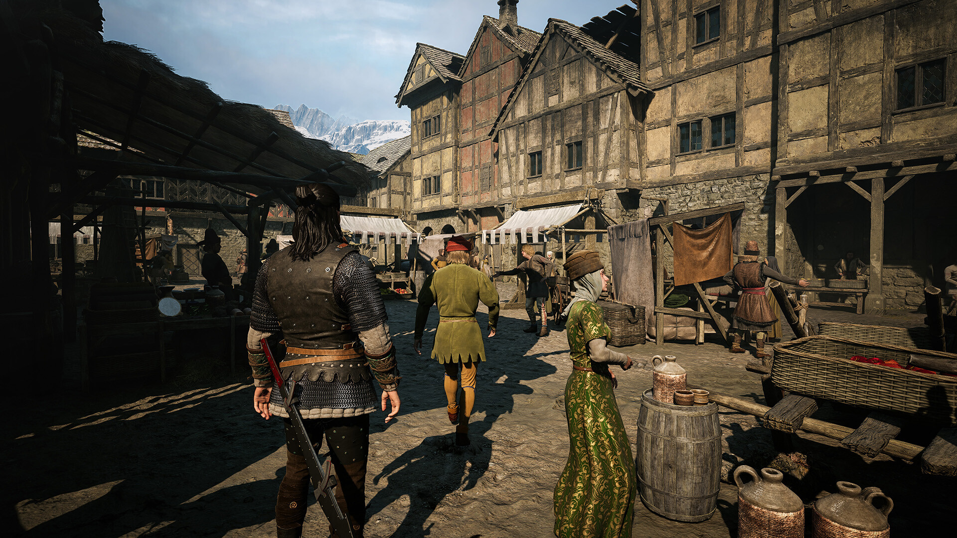 A busy daytime street of timber framed houses and market stalls, with townsfolk in period clothing and an armed traveller walking through