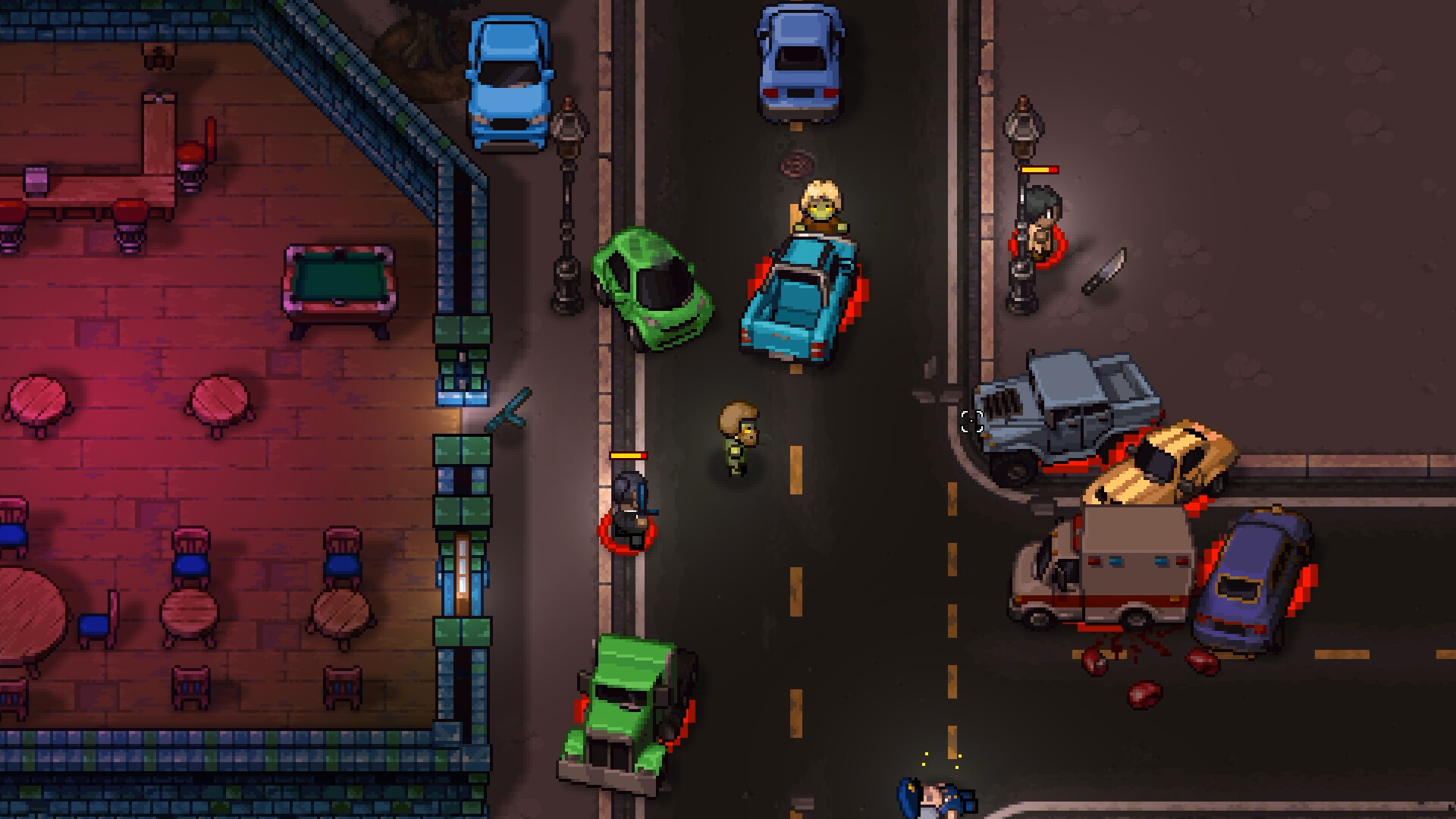 A night-time street fight in a Streets of Rogue 2 city, with hostile NPCs ringed in red and carrying yellow health bars, a dropped knife on the pavement, blood spatter, damaged cars and an ambulance, beside a bar interior containing a pool table