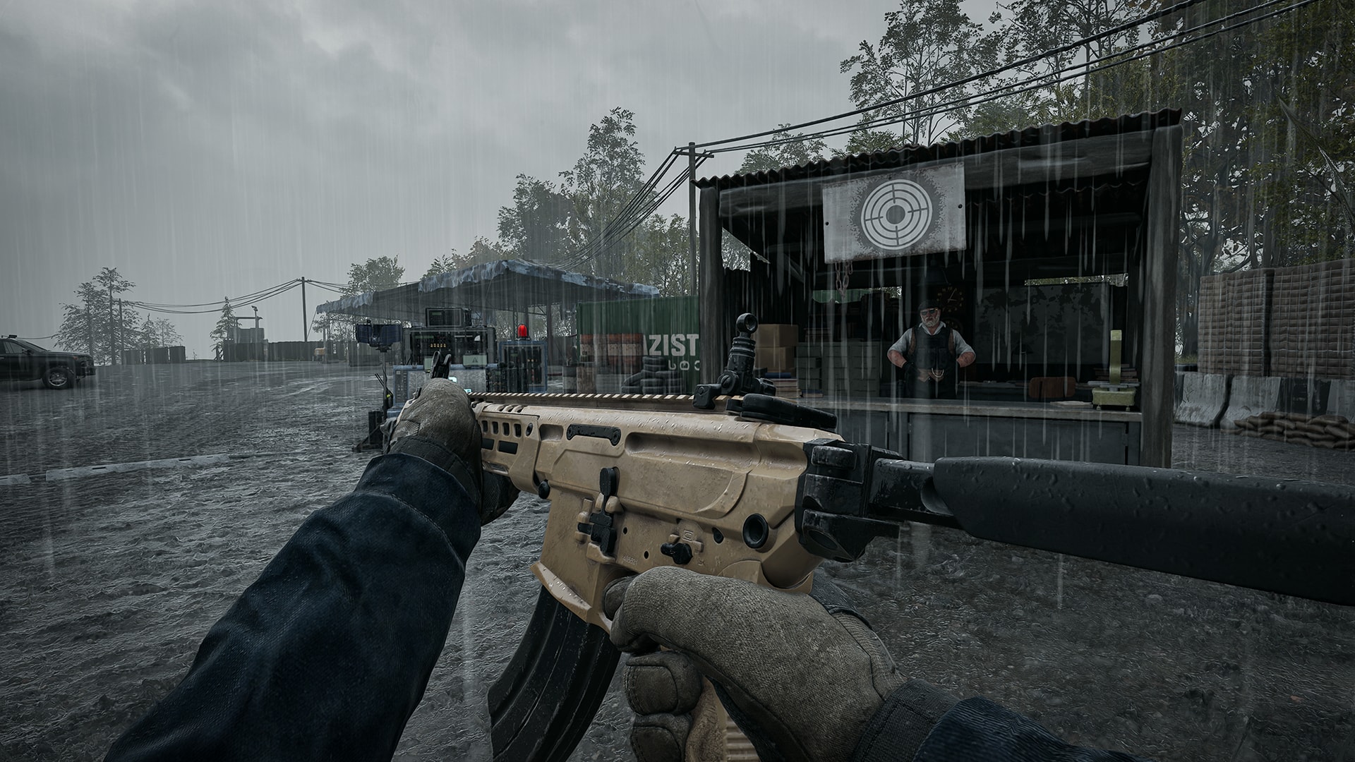 First-person view of the tan TCX Spear assault rifle with a long suppressor, held in the rain beside a vendor stall at a firing range in WARDOGS