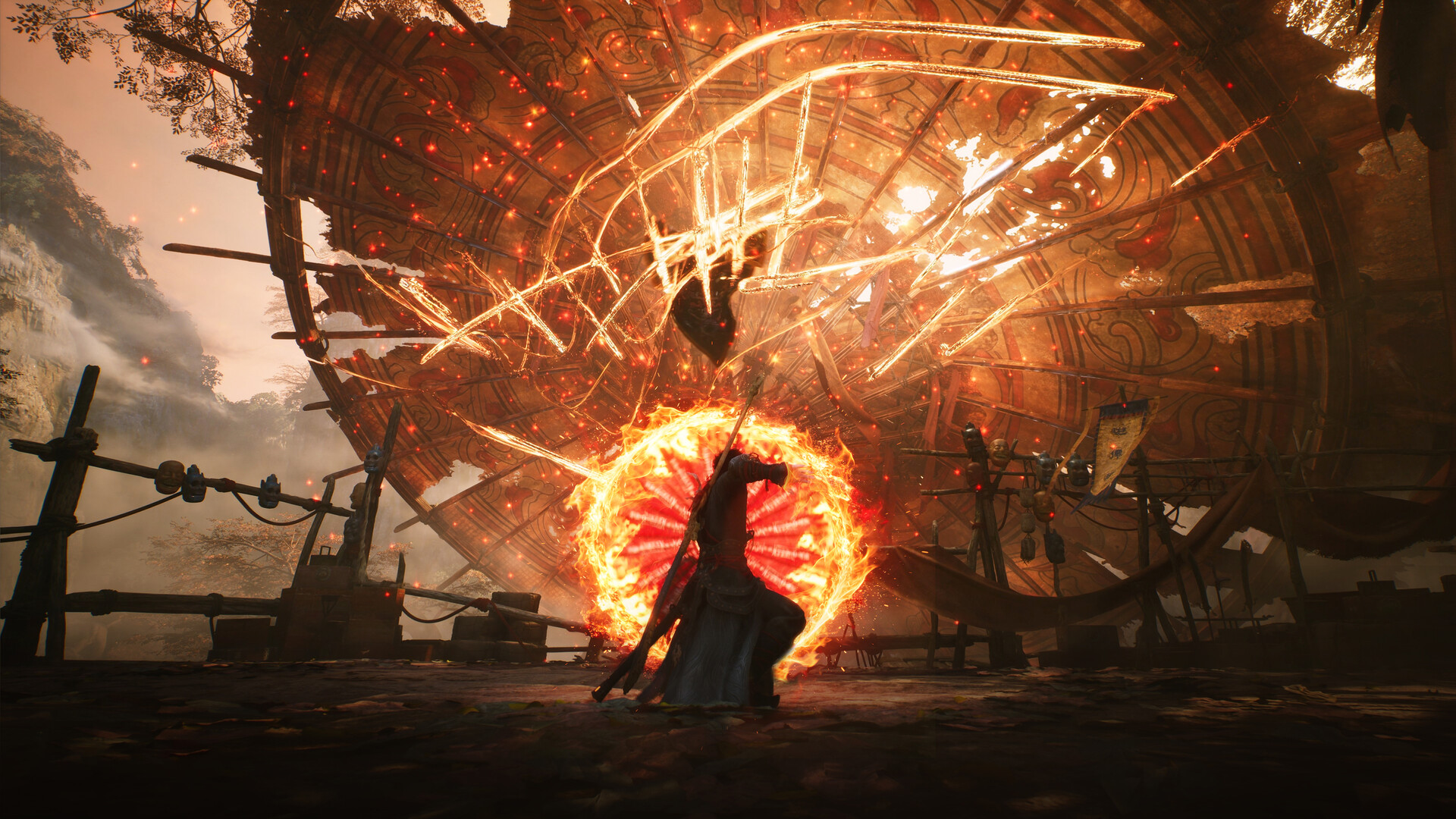 A vast burning wheel behind the player character, who stands braced inside a ring of fire.