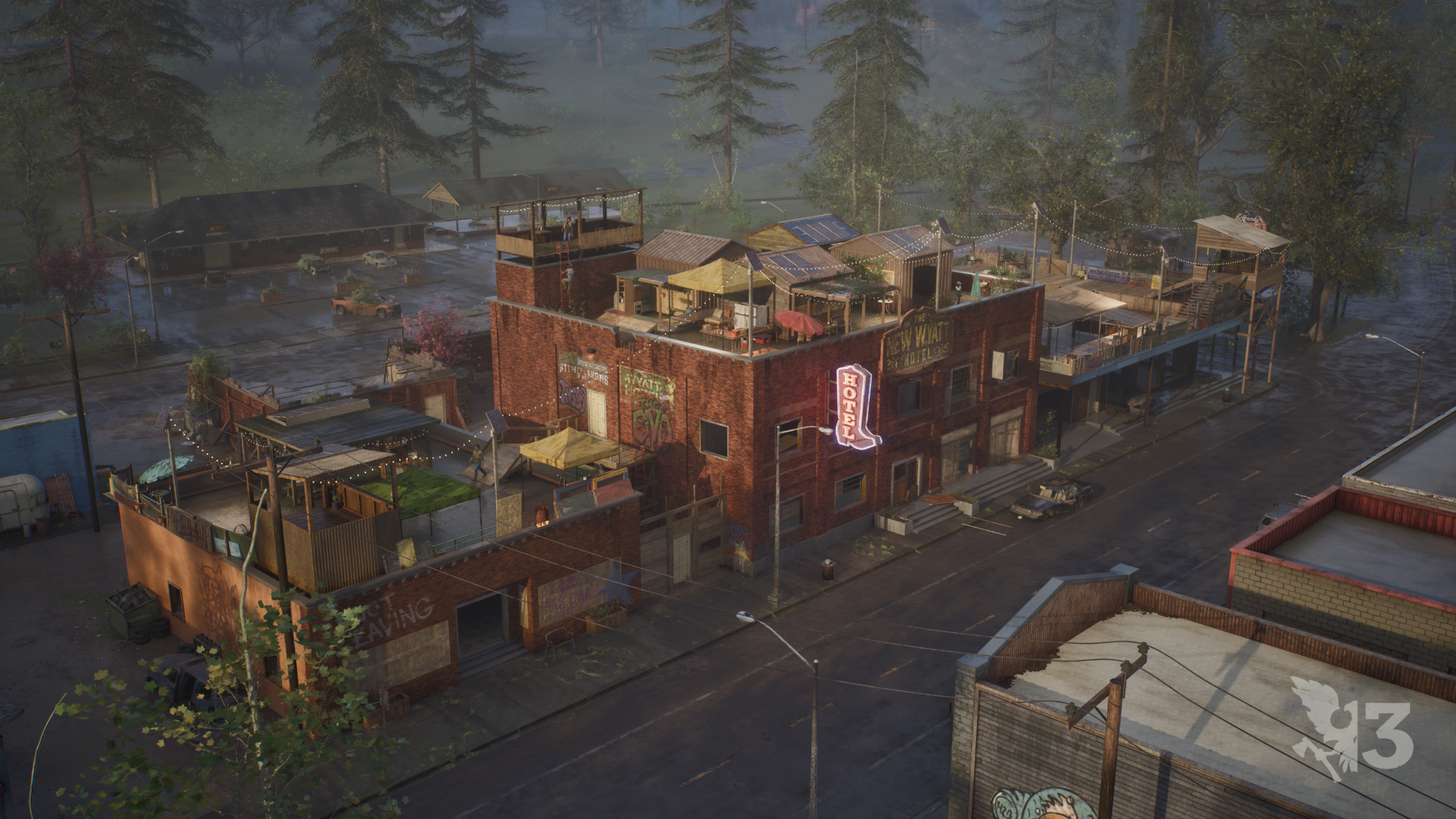 An overhead view of a settlement built into a downtown block around a converted hotel, with rooftop gardens, solar panels, awnings and lookout platforms above a wet street.