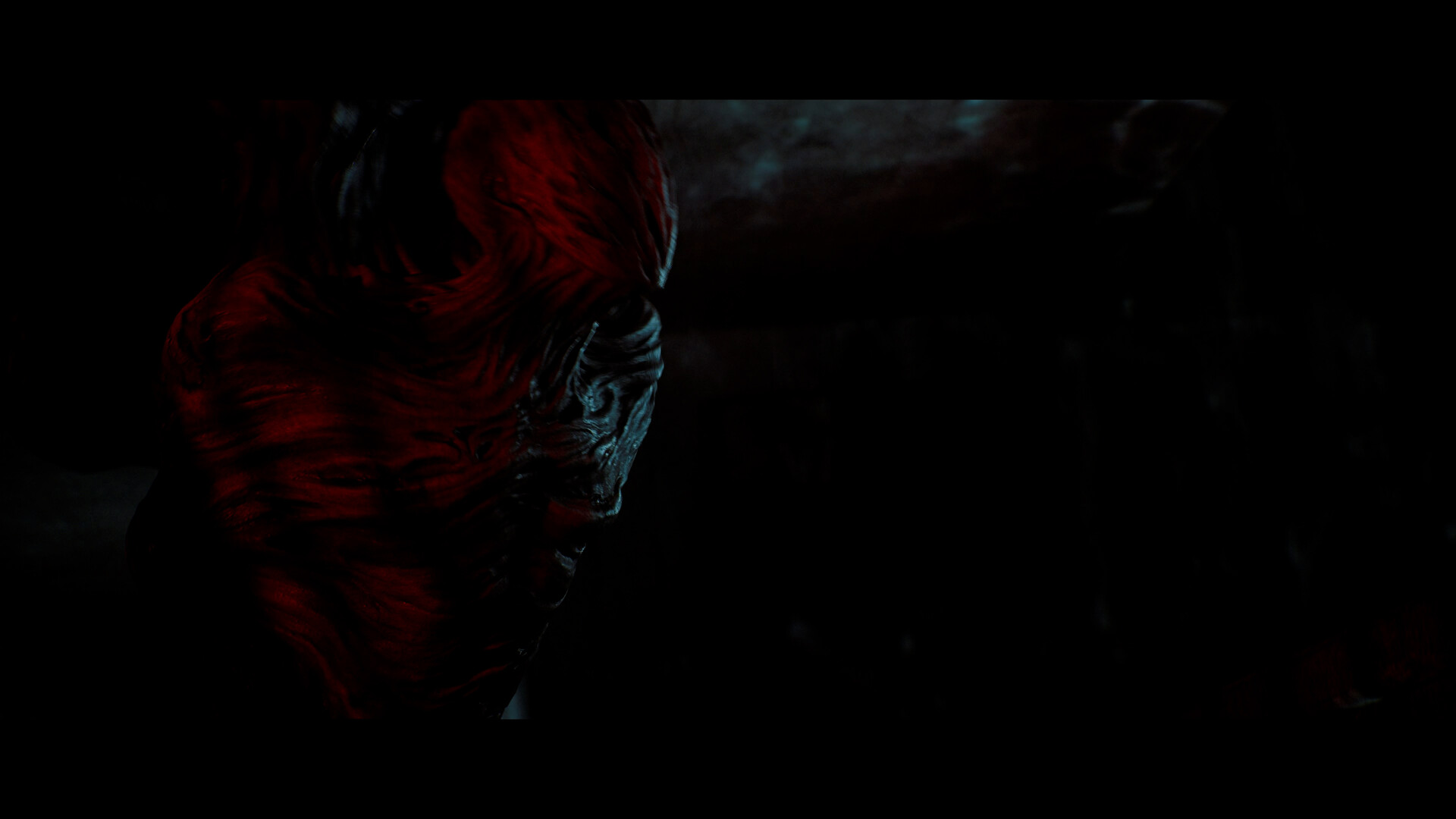 Close view of a creature's folded, red-lit head
