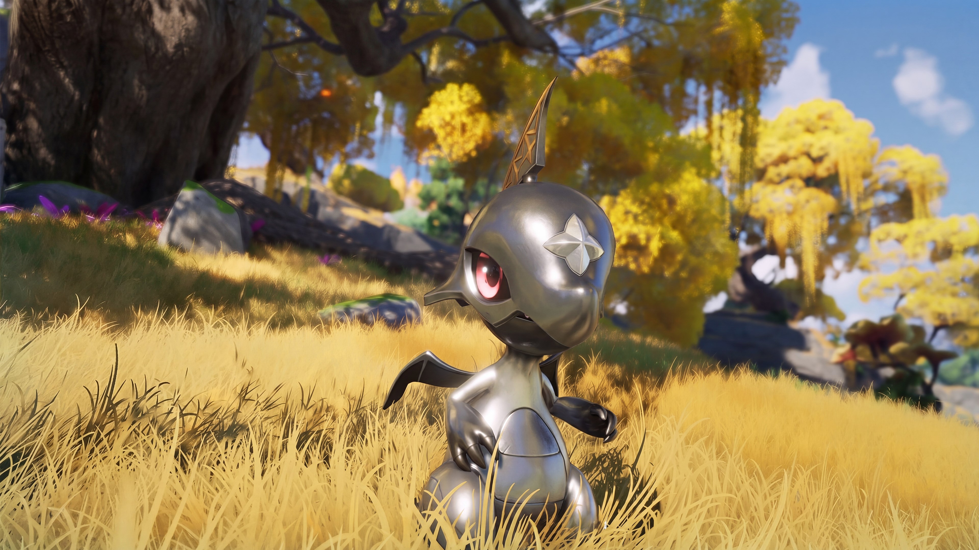 A silver, round-eared Aniimo standing in tall golden grass beneath an autumn tree