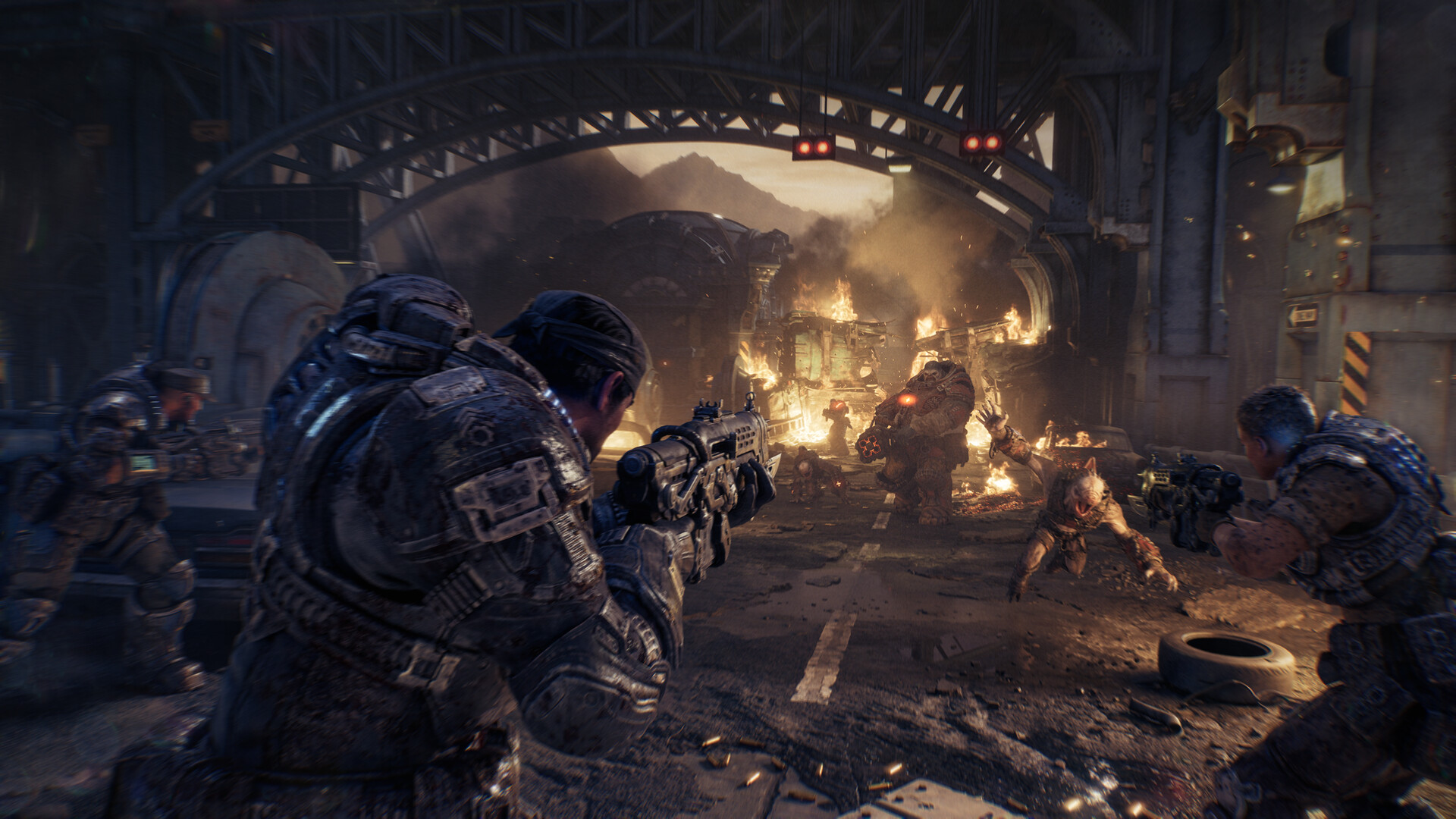 Three armoured figures fire beneath the steel framework of a bridge, with cars and flames nearby.